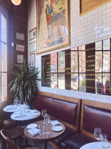 Boucherie West Village's brasserie dining room, with leather banquettes, marble-top tables and vintage French posters