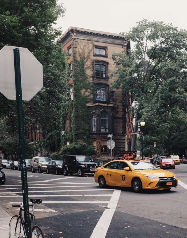 Best Areas to Stay in New York – a Complete Guide for First-Timers new york yellow taxi driving past a brick townhouse